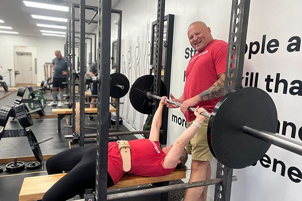 adam helps jessica rack at the end of a pr 135 lb bench press