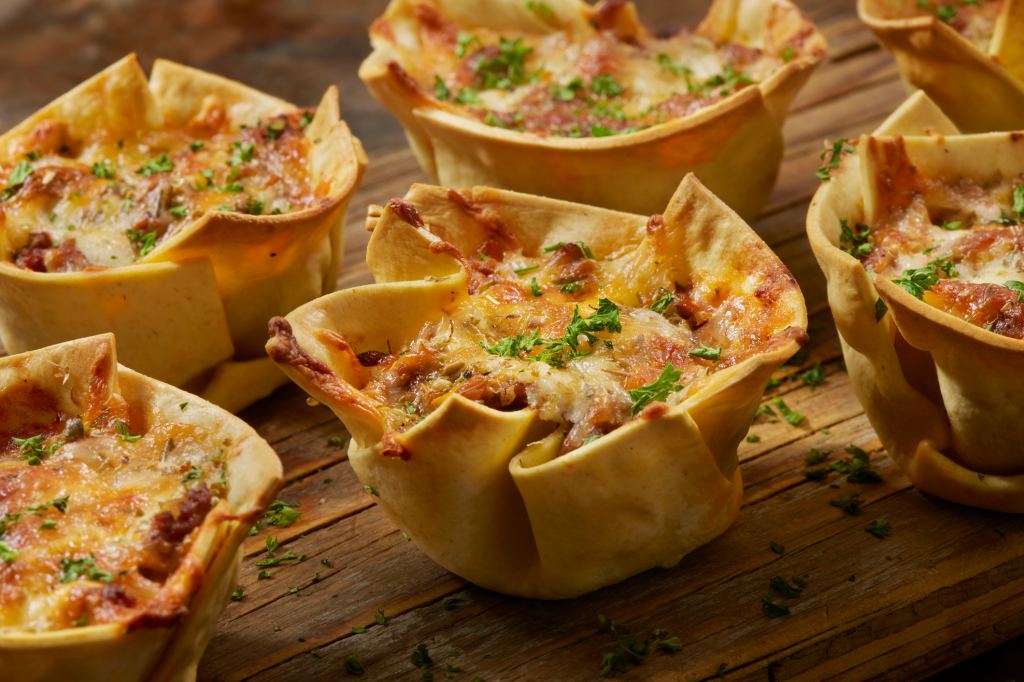 Lasagna cups on a wooden serving board