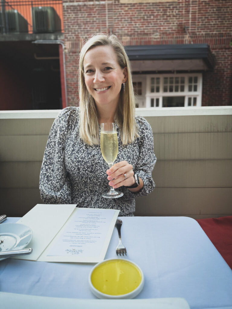 Kath Eats Blogger Kath Younger shares her October - in photo: Kath holding a glass of white wine