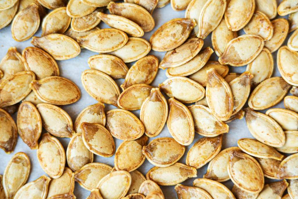 close up of roasted pumpkin seeds on parchment paper