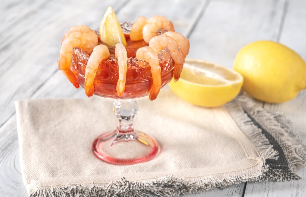 shrimp cocktail in glass with lemon wedge