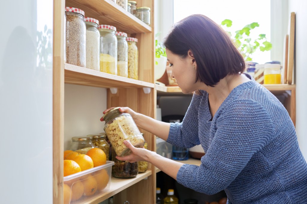 mature woman decluttering pantry