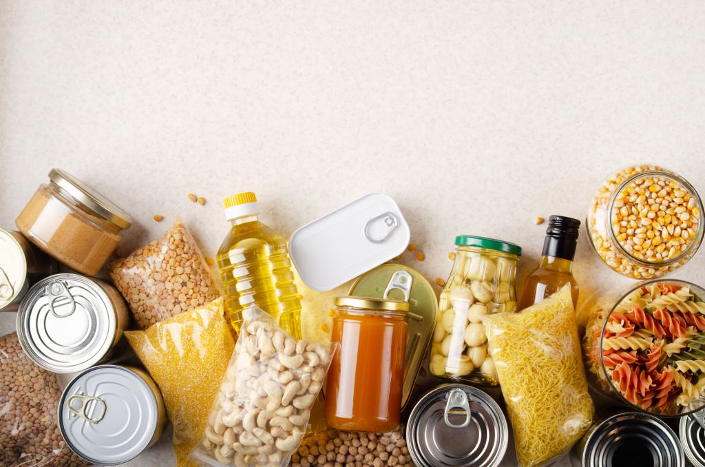 Flat lay view at kitchen table full with non-perishable foods for the TikTok Pantry Challenge