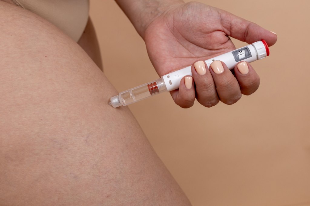 woman injecting ozempic in thigh