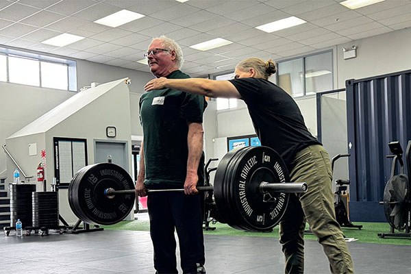 mia inman cues a lifter during the deadlift