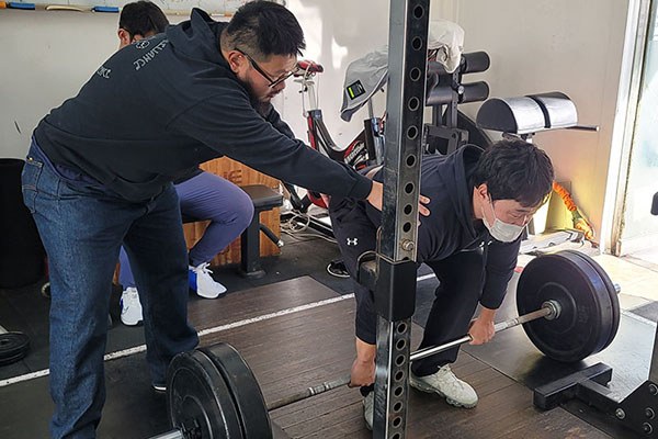 inhyuk eun corrects the back angle of a lifter's deadlift