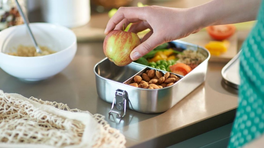 Woman packing healthy food for lunch ; Are almonds good for weight loss