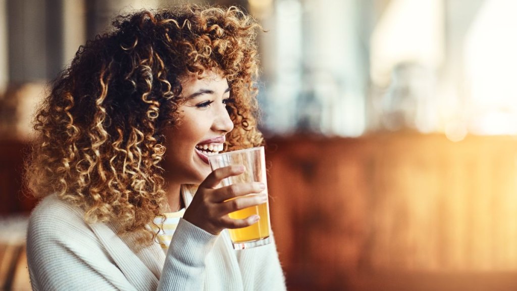 Shot of a young woman enjoying a drink at a bar