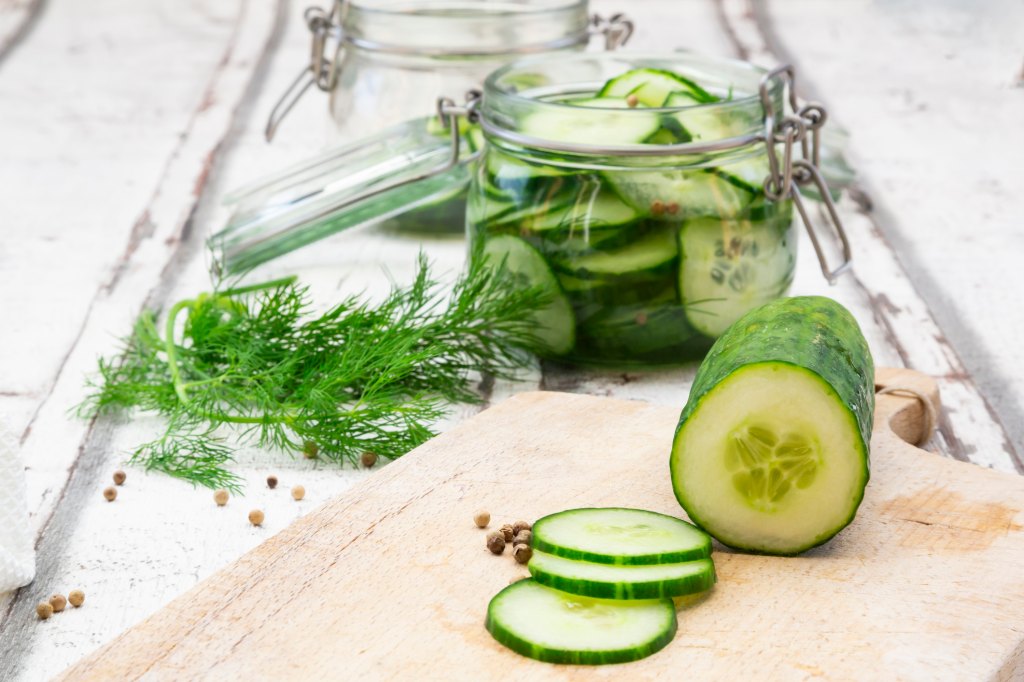 Cucumbers being pickled as part of a guide on how to pickle cucumbers