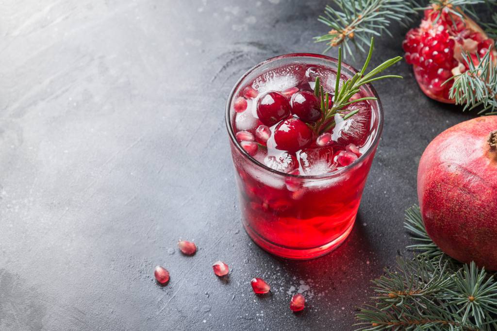 sparkling water mocktail for the holidays with pomegranate seeds and rosemary