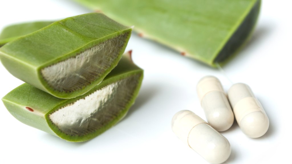 aloe leaves pictured with pills to convey natural aloe vera supplement