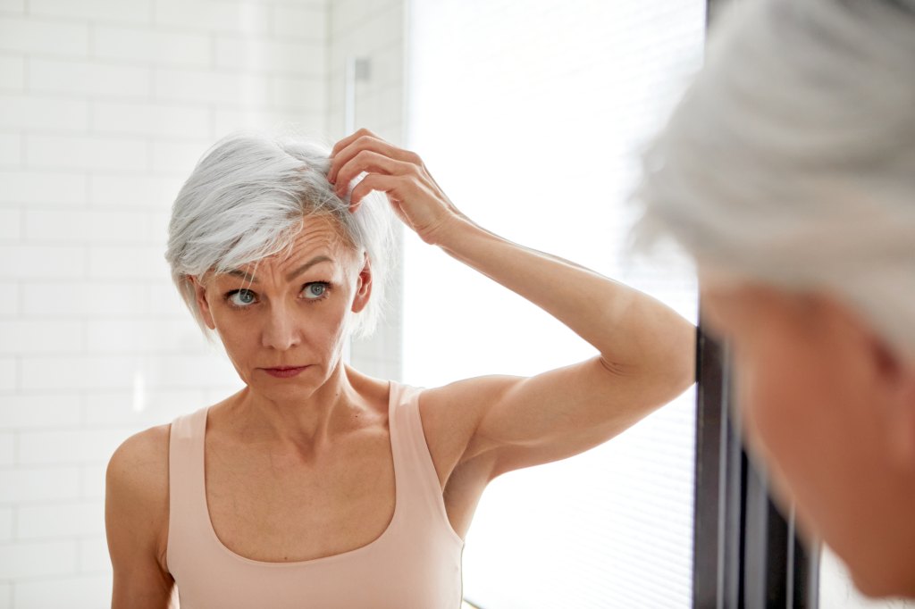 mature woman looking at hair loss