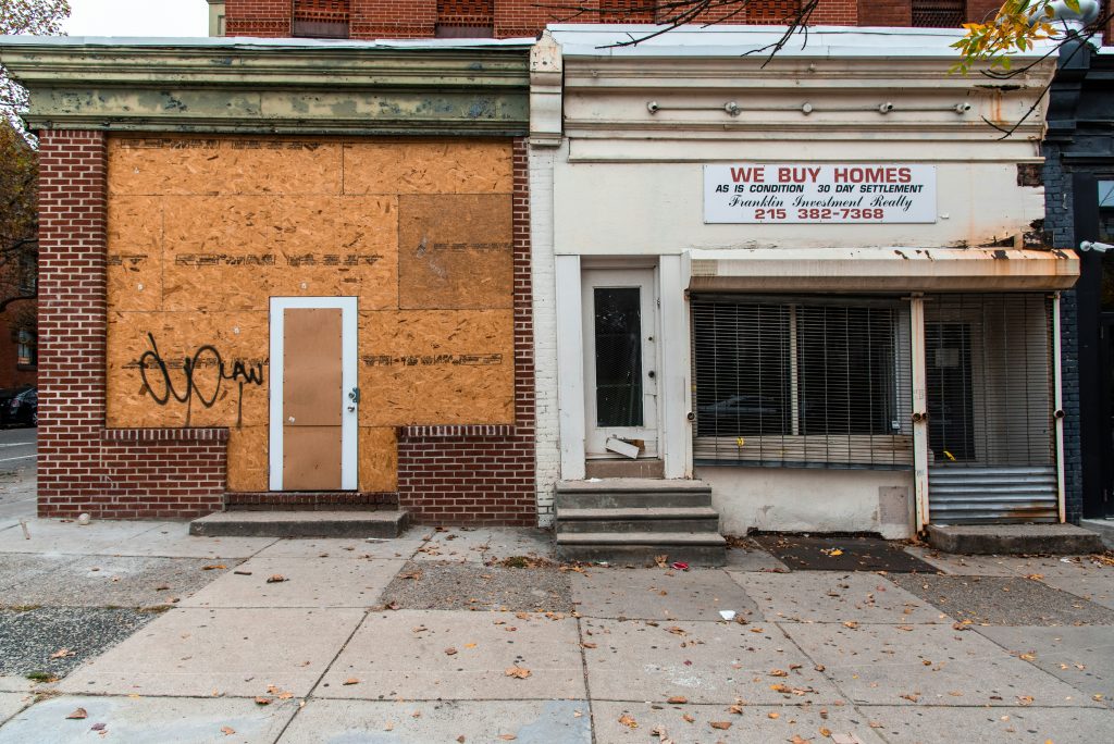 brown brick building with boarded up window