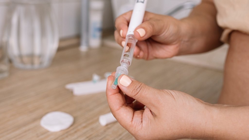 A close-up of a woman holding an Ozempic dosing pen to aid with weight loss