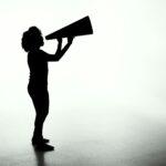 silhouette of woman holding megaphone