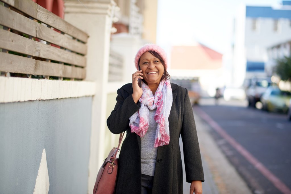 woman walking while talking on the phone outside as part of her prediabetes self-care routine