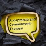 Acceptance and commitment therapy. Torn dark paper and speech bubble.