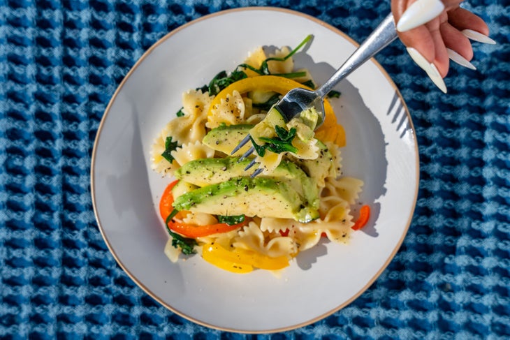 Avocado pasta atop a bed of farfalle pasta