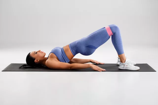 HIIT workout exercises. Woman doing glute bridge. 