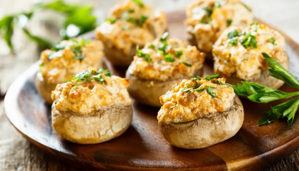 Parmesan-artichoke stuffed mushrooms as part of a recipe roundup of New Year's Eve appetizers