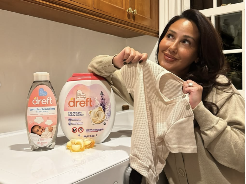 woman holding baby clothes