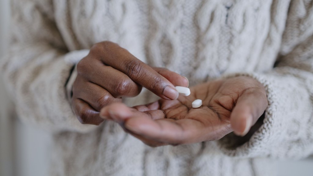 Woman holding pills in hand