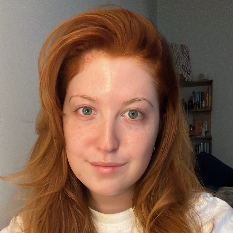 person with long wavy orange hair wearing a white tshirt