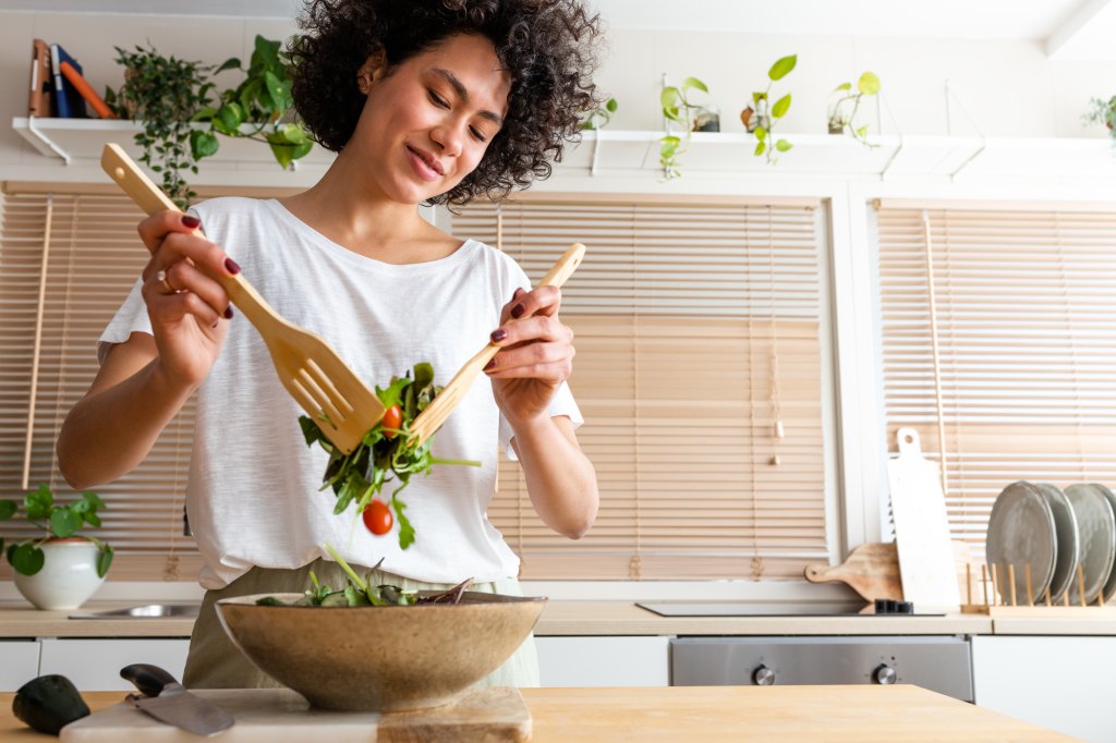 Healthy woman smiles and prepared salad for a meal