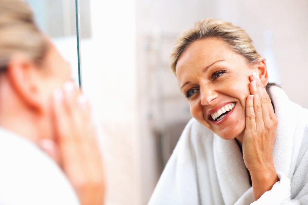 mature woman looking at glowing skin