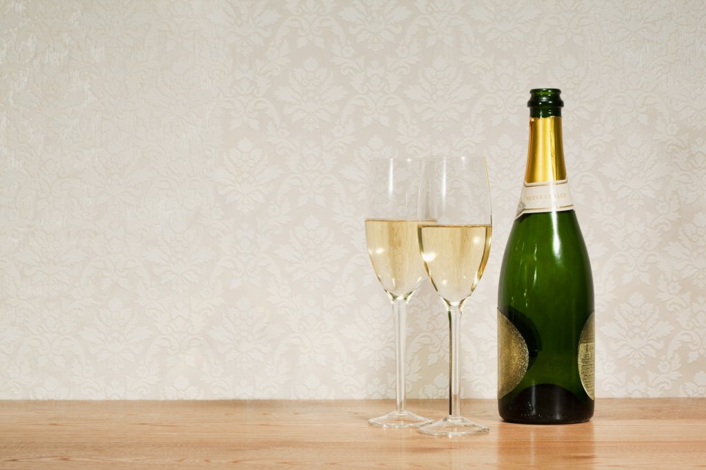 champagne bottle and two glasses on table