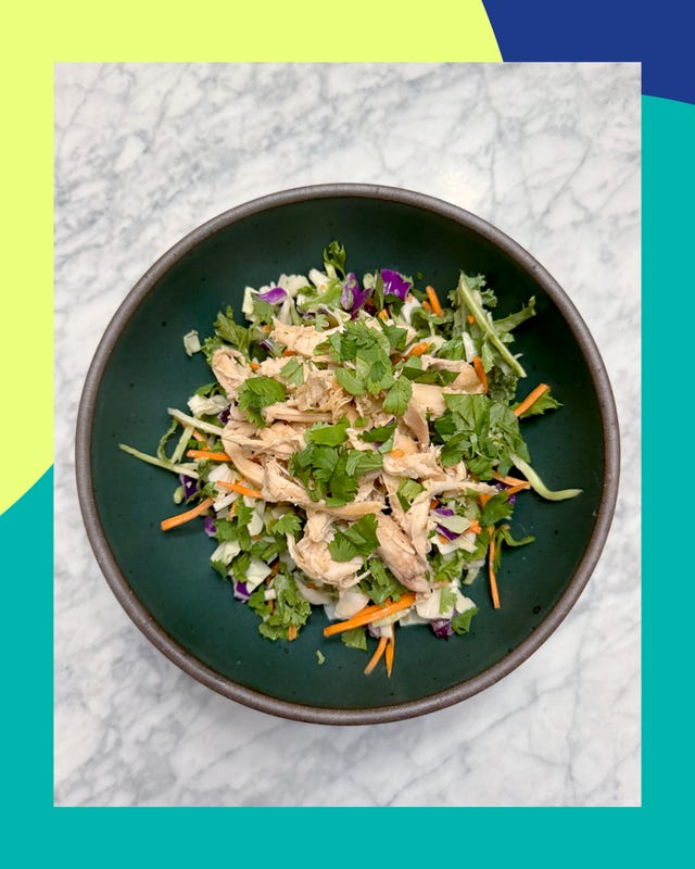 bowl of salad with shredded chicken and fresh herbs