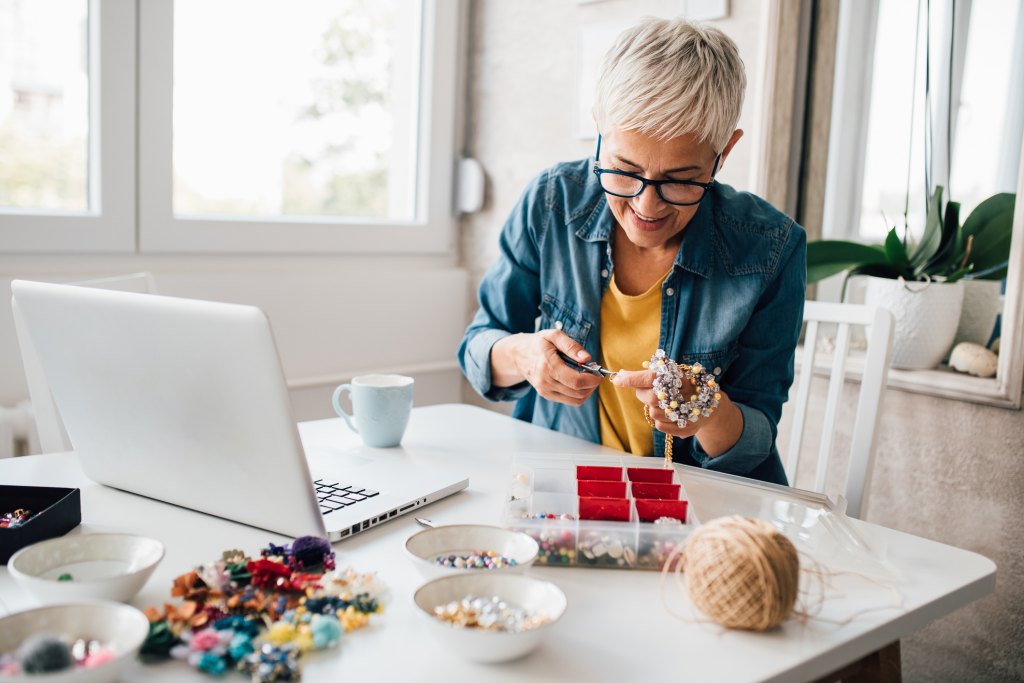 mature woman making a charm bracelet