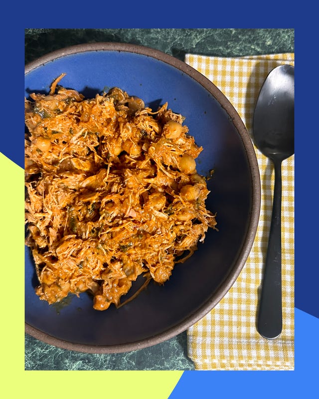 a bowl of shredded chicken dish with chickpeas placed on a checkered napkin