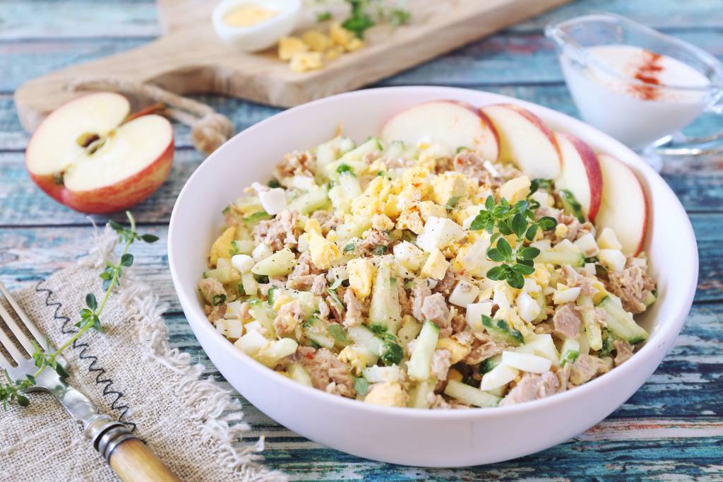 tuna salad with apples, cucumber, eggs and spicy wasabi in bowl