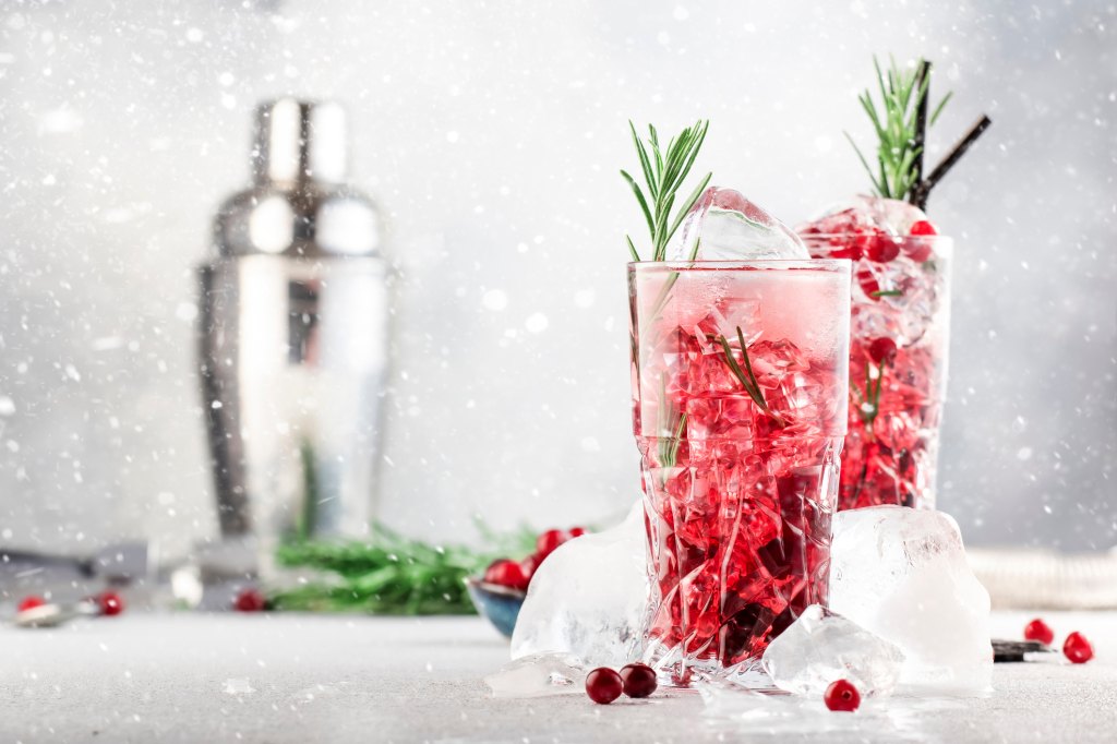 tall glasses of snow globe cocktails with liquor, gin, vodka and cranberries