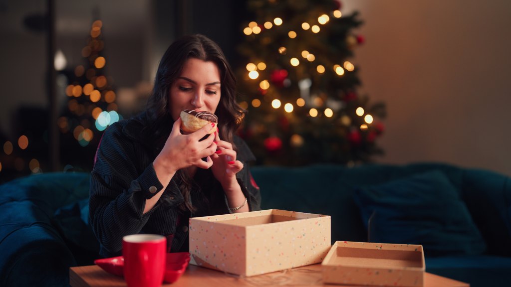 woman eating a free doughnut from the Krispy Kreme 'day of the dozens' deal