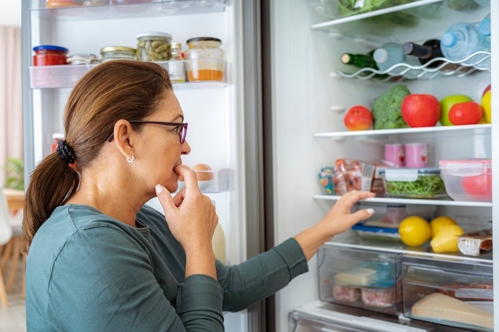 woman with controlled appetite looking at fridge while on zepbound or wegovy weight loss medications