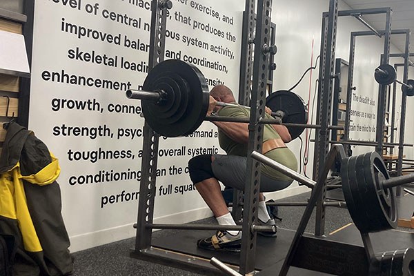 lifter at the bottom of a squat inside a rack