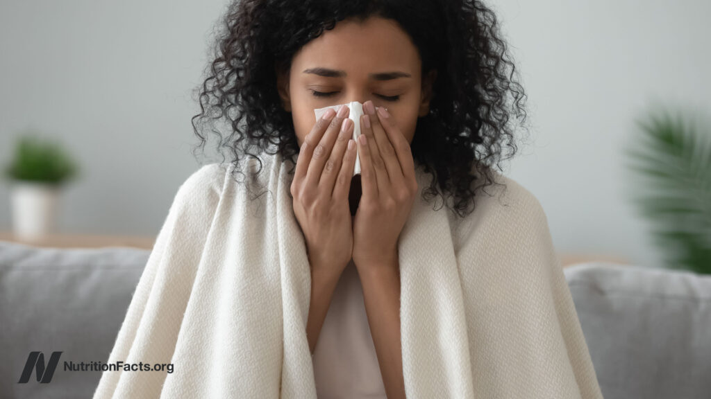 Woman sneezing into a tissue