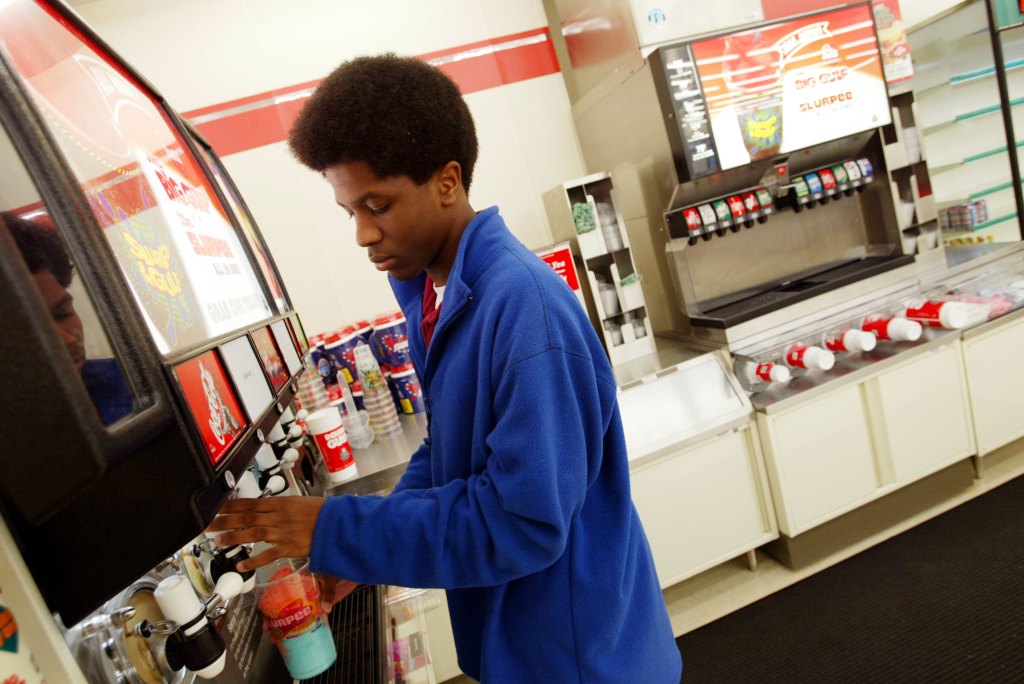 a young man pouring himself a slurpee