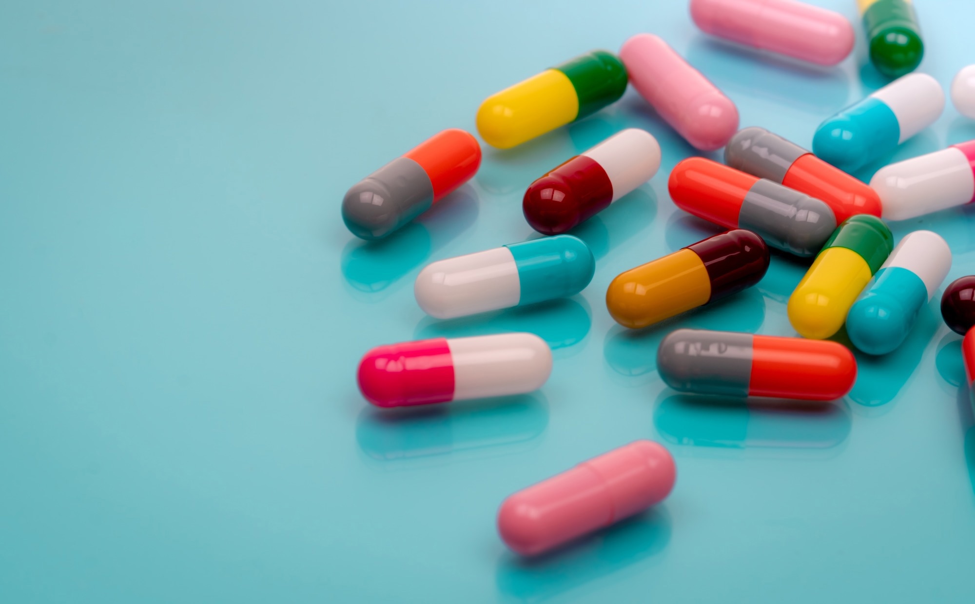 Antibiotic capsule pills on blue background.