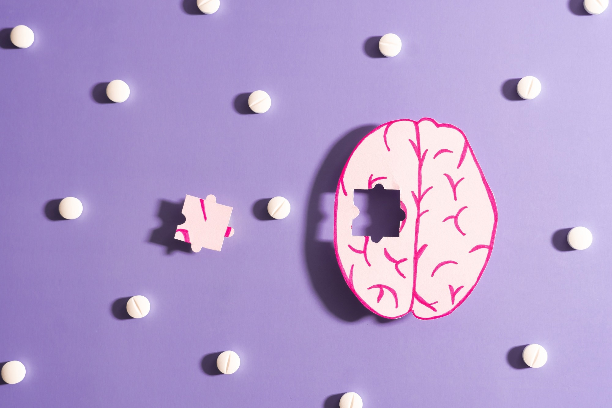 Human brain anatomy missing a piece of jigsaw puzzle with medicine pills on purple background.