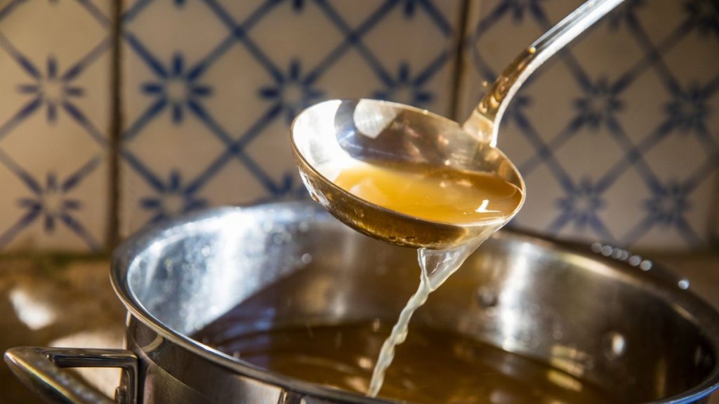 Broth being ladled from saucepan