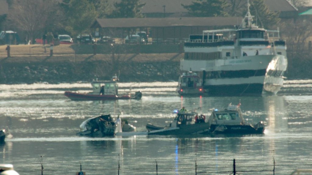 Emergency response units search the wreckage of an American Airlines plane on the Potomac River