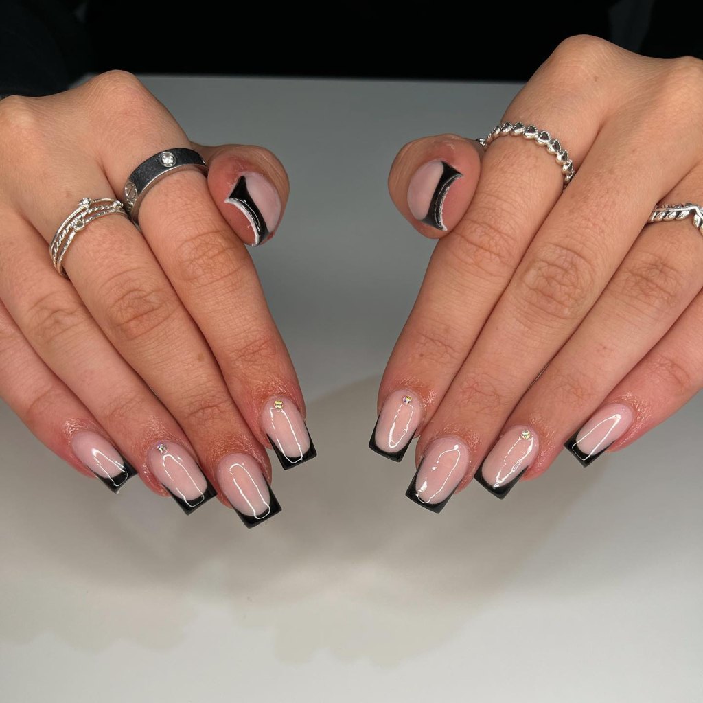 Black French tip nails with rhinestone accents