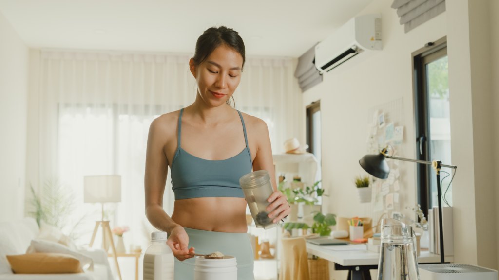 Fit woman makes a creatine shake to drink.