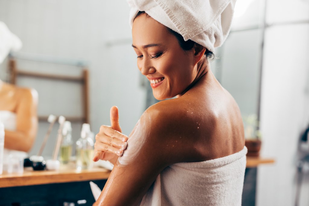 woman applying moisturizer to skin