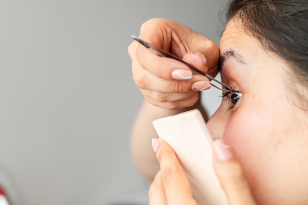 woman applying lash clusters