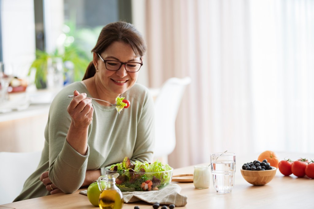 woman eating a salad at table