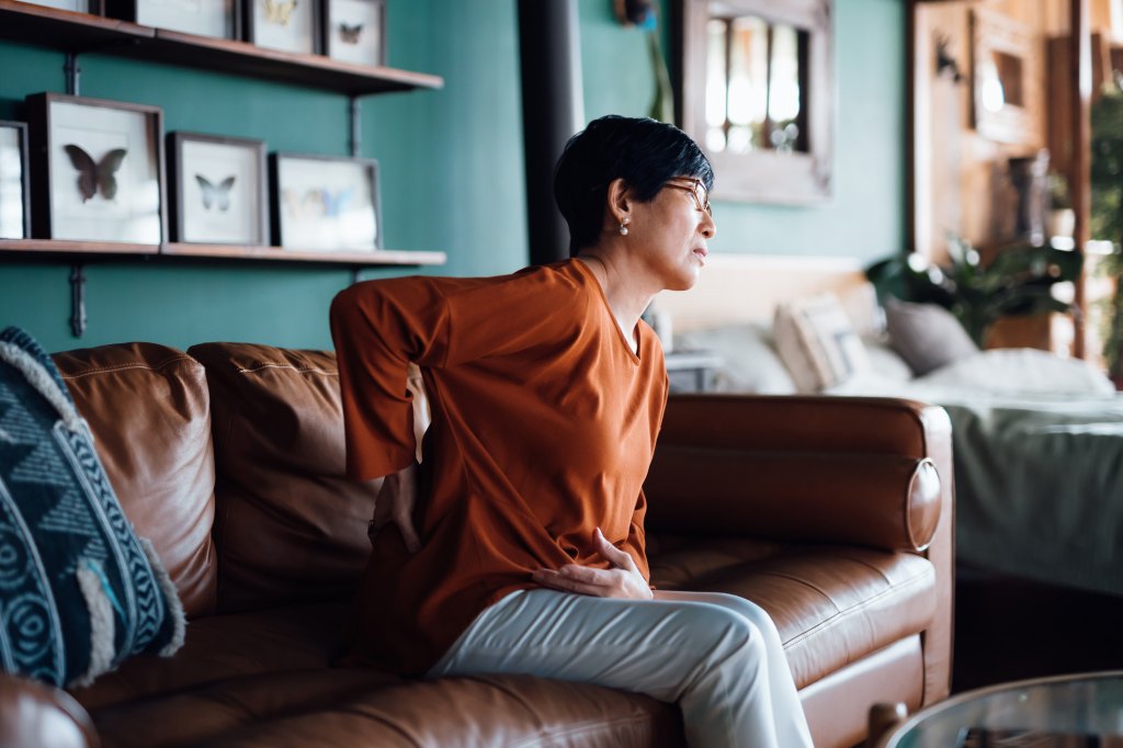 woman with chronic back pain trying gentle stretches as a natural remedy